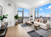Thumbnail 7 of 43 - A living room with a large window and a view of the city.