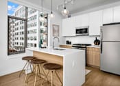 Thumbnail 1 of 43 - A modern kitchen with a white countertop and stainless steel appliances.