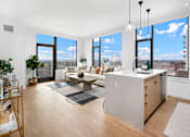 Thumbnail 10 of 43 - A modern kitchen with a large island and a view of the city.