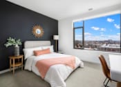 Thumbnail 3 of 43 - A bedroom with a large bed and a view of the city through the window.