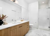 Thumbnail 13 of 43 - A bathroom with a white sink, toilet, and a walk-in shower.
