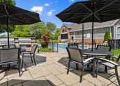 Thumbnail 22 of 37 - a patio with tables and umbrellas next to a swimming pool