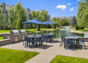 Thumbnail 23 of 37 - a patio with tables and chairs and umbrellas next to a pond