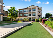 Thumbnail 45 of 47 - A sunny day at a residential area with apartment buildings and a green lawn.