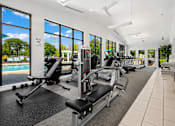 Thumbnail 11 of 30 - A gym with a row of treadmills and exercise machines.