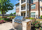 Thumbnail 43 of 47 - A stone BBQ grill is in front of a building.
