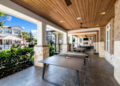 Thumbnail 34 of 47 - A black table is in the middle of a patio.