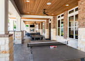 Thumbnail 37 of 47 - A ping pong table is in the middle of a covered patio.