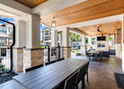Thumbnail 35 of 47 - A wooden table is in the middle of a patio.