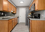 Thumbnail 20 of 30 - A kitchen with wooden cabinets and a white refrigerator.