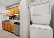 Thumbnail 7 of 30 - A white dryer is sitting next to a white washer in a small laundry room.