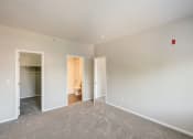 Thumbnail 15 of 23 - a bedroom with a carpeted floor and a door to a bathroom