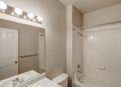 Thumbnail 16 of 23 - a bathroom with a white tub and a sink and a mirror