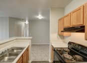 Thumbnail 17 of 23 - a kitchen with wood cabinets and a stove top oven and a sink