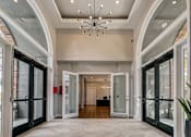 Thumbnail 5 of 40 - a foyer with glass doors and a chandelier