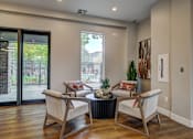 Thumbnail 7 of 40 - a living room with chairs and a table and a sliding glass door