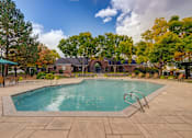 Thumbnail 16 of 40 - a swimming pool with trees and a house in the background