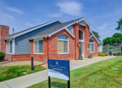 Thumbnail 1 of 23 - a red brick home with a blue sign in front of it