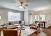 Thumbnail 18 of 32 - Aurora, CO Apartments For Rent - Sonoma Resort At Saddle Rock - Living Room With Couch, Wood-Style Flooring, Coffee Table, Two Chairs, Floor Lamp, Area Rug, Ceiling Fan, And Windows.