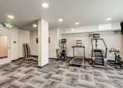 Thumbnail 9 of 25 - A gym with treadmills, elliptical machines, and other exercise equipment.