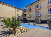 Thumbnail 30 of 33 - an apartment building with a pool and a palm tree