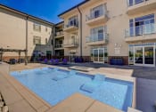 Thumbnail 25 of 33 - an apartment building with a pool and chairs in front of it