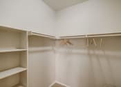 Thumbnail 26 of 32 - a walk in closet with shelves and hangers