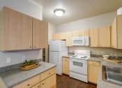 Thumbnail 22 of 32 - a kitchen with white appliances and granite counter tops