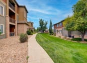 Thumbnail 32 of 32 - a walkway between two apartment buildings with grass and trees