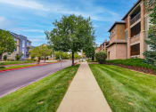 Thumbnail 31 of 32 - the view of a city street with apartment buildings and grass and trees