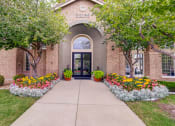 Thumbnail 1 of 32 - the front of a brick building with flowers and trees