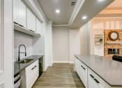 Thumbnail 12 of 32 - a large kitchen with white cabinets and a sink