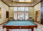 Thumbnail 15 of 32 - a pool table in the corner of a room with a large window