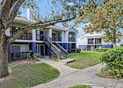 Thumbnail 34 of 61 - A tree in front of a blue building with a white roof.