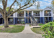 Thumbnail 35 of 61 - A tree in front of a two-story building with a balcony.