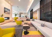 Thumbnail 38 of 43 - A modern living room with a yellow chair and a white sofa.