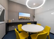 Thumbnail 27 of 43 - A conference room with a white table and yellow chairs.