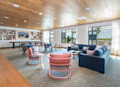 Thumbnail 21 of 43 - A modern living room with a wooden ceiling and a large window.