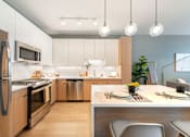 Thumbnail 6 of 43 - A modern kitchen with a dining table set for two.