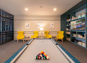 Thumbnail 34 of 43 - A pool table with a yellow chair and a blue bookshelf.