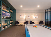 Thumbnail 32 of 43 - A pool table is in the middle of a room with a blue carpet.