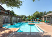 Thumbnail 21 of 48 - a swimming pool with chairs and umbrellas in front of a house