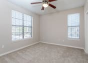 Thumbnail 37 of 48 - an empty bedroom with a ceiling fan and two windows