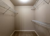 Thumbnail 33 of 48 - a spacious walk in closet with two shelves and a mirrored wall with two hanging racks