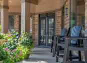 Thumbnail 26 of 48 - a porch with chairs and a table and a door