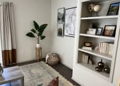 Thumbnail 23 of 40 - a living room with a bookshelf and a potted plant