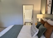Thumbnail 29 of 40 - a bedroom with a large bed and a bathroom in the background