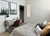 Thumbnail 26 of 40 - a bedroom with a bed and a desk in a room