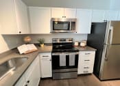 Thumbnail 18 of 40 - a kitchen with white cabinets and stainless steel appliances