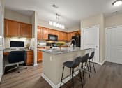 Thumbnail 3 of 48 - Riverstone - Open Kitchen with Granite Countertops, Shaker Style Cabinetry with Brushed Nickel Hardware Pulls, and Wood Plank Flooring